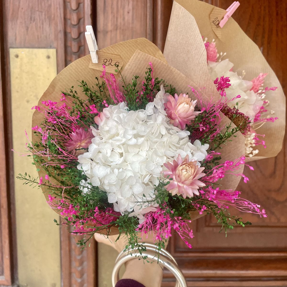 Bouquet à l'hortensia blanc et fleurs roses dans son papier kraft, création Un Jardin en Ville, fleuriste à Bordeaux